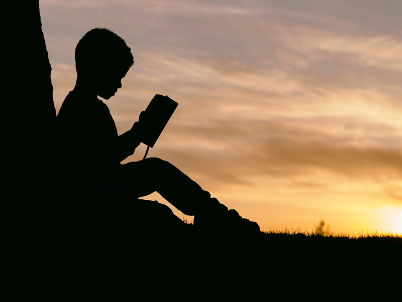 Silhouette of a child reading